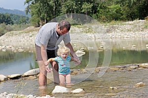 Father and toddler playing in the river