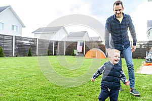 Father and toddler son camped in the backyard