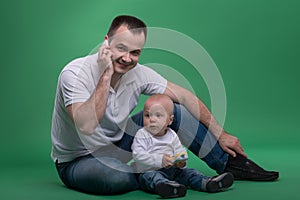 Father and toddler son playing with toy cell phone