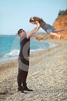 Father toss up daughter playing together on the beach carefree h