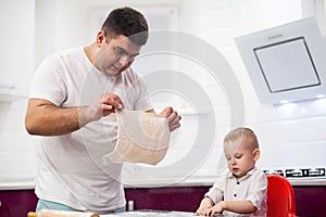 Father tossing pizza dough. Happy family in kitchen