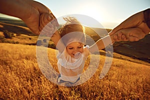 Father turns a child in the field in nature.