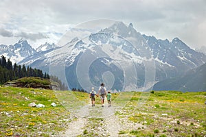 Father and two boys hike in mountain