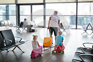 Father with two children in the airport terminal fly together on vacation