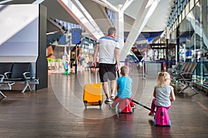 Father with two children in the airport terminal fly together on vacation