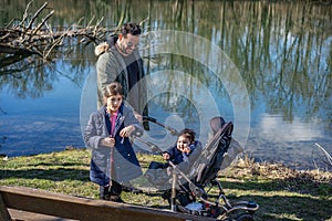 Father with two children is walking along the Aare river in springtime