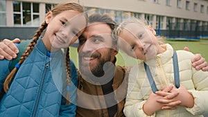 Father and two daughters looking at camera smiling laughing happy family parenting love joy elementary school learners photo