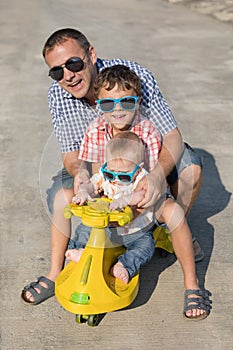 Father and two sons playing on the road at the day time