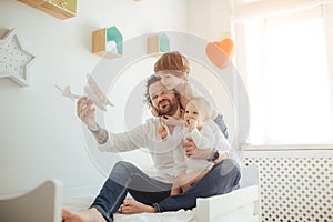 Father of two sons playing with a toy plane