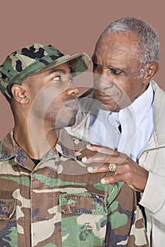 Father and US Marine Corps soldier looking at each other over brown background