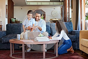 Father using a laptop at home with children. A happy dad online with his a and daughter. Young man with a little boy and