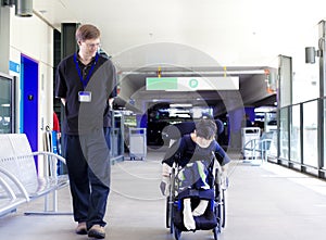 Father walking with disabled son in wheelchair to the hospital