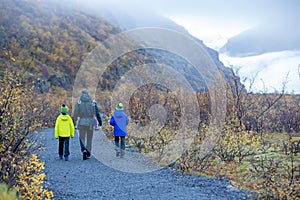 Father, walking with his children on a path towards Skaftafell Glacier national park on a gorgeous autumn day in Iceland