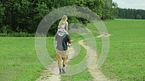 Father walking road daughter sitting on his neck