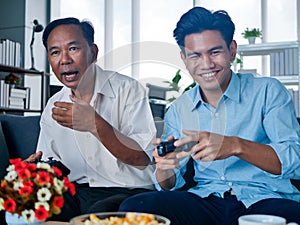 Father was spending time with mature adult son at home  on couch