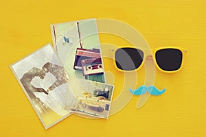 Father& x27;s day concept. Hipster yellow sunglasses and funny moustache next to photographs