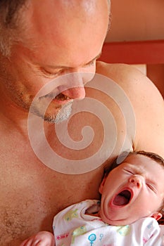 Father and yawning newborn baby