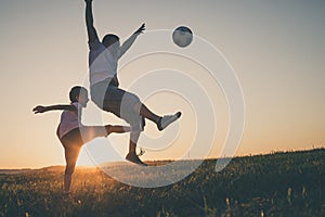 Father and young little boy playing in the field  with soccer ball