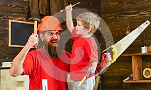 Fatherhood concept. Boy, child cheerful holds spanner wrench, learning use tools with dad. Father, parent with beard in