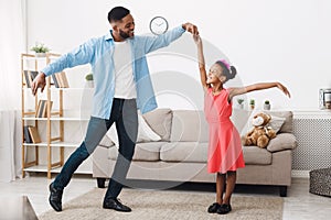 Fatherhood concept. Cute girl dancing with father