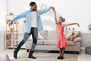 Fatherhood concept. Cute girl dancing with father photo