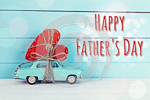 Fathers day background with miniature blue toy car carrying a he