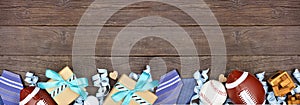 Fathers Day bottom border of gifts, ties, games and sport items on a rustic wood banner background
