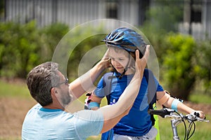 Fathers day concept. Father and son in bike helmet learning ride bicycle. Father and son on bicycle on summer day