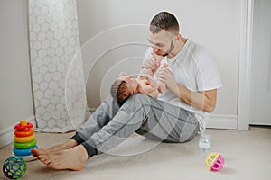 Fathers Day holiday. Caucasian father playing kissing  newborn baby. Parent holding rocking cute funny child daughter, son.