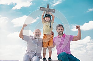 Fathers day. Kid having fun with toy plane. Men generation family with three different generations ages grandfather