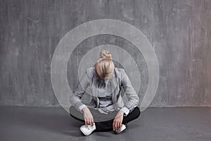 Fatigue, professional burnout. Young woman in business suit sitting in Lotus pose, head down