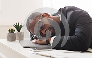 Fatigue young afro businessman sleeping in office