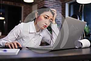 Fatigued marketing company employee with painful headache sitting tired in office workspace.