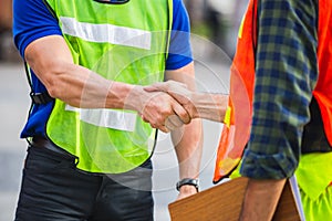 Fatory worker handshake with blurred construction site, Success and Teamwork concept