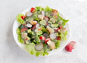 Fattoush salad with cucumber, tomatoes, radishes and toasted pita bread. Top view.
