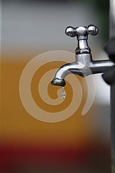 Faucet dripping water drop