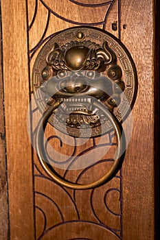 Faucet knocker on wooden door of ancient Chinese building