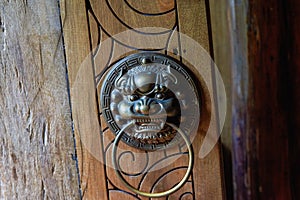 Faucet knocker on wooden door of ancient Chinese building