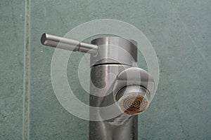 Faucet limescale. Dirty faucet aerator with limescale, calcified shower water tap with lime scale in bathroom, close up. Selective