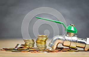 Faucet on money coin wood background / water savings and faucet money fall