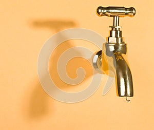 Faucet in orange wall with water drop