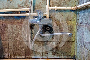 faucet or sink and rusty tubes and pipes on a dirty rusty wall