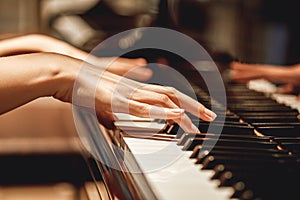 Favorite classical music...Close up view of gentle female hands playing a melody on piano while taking piano lessons