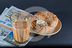 Favorite indian breakfst with tea and bun butter against black background