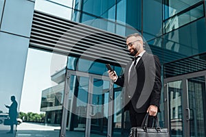 Favorite music during break from job. Smiling mature businessman walking during break outdoors, free space