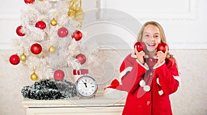 Favorite part decorating. Getting child involved decorating. Girl smiling face hold balls ornaments white interior