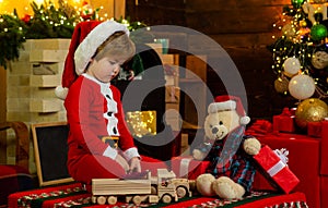 Favorite toy. Family holiday. Childhood memories. Santa boy little child celebrate christmas. Boy child play near