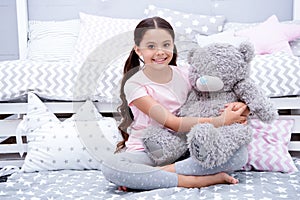 Favorite toy. Girl child sit on bed hug teddy bear in her bedroom. Kid prepare to go to bed. Pleasant time in cozy