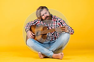 favorite tune. Portrait of happy bearded male playing guitar. a lonely musician. cheerful handsome mature man playing