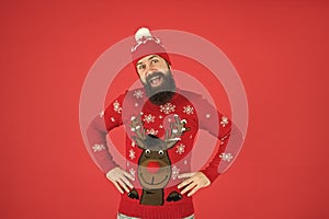 Favorite winter season indoor activities. Hipster bearded man wear winter sweater and hat red background. Happy new year